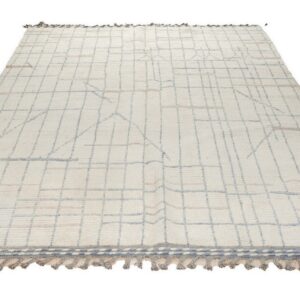 Cream high-pile rug with blue-gray and tan abstract grid lines and braided gray tassels on a white background.