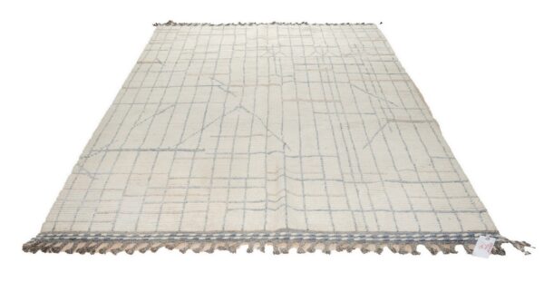 Cream high-pile rug with blue-gray and tan abstract grid lines and braided gray tassels on a white background.