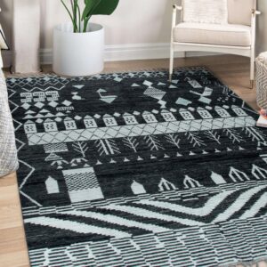 A black and pale blue geometric patterned rug covers light wood flooring near a white armchair.