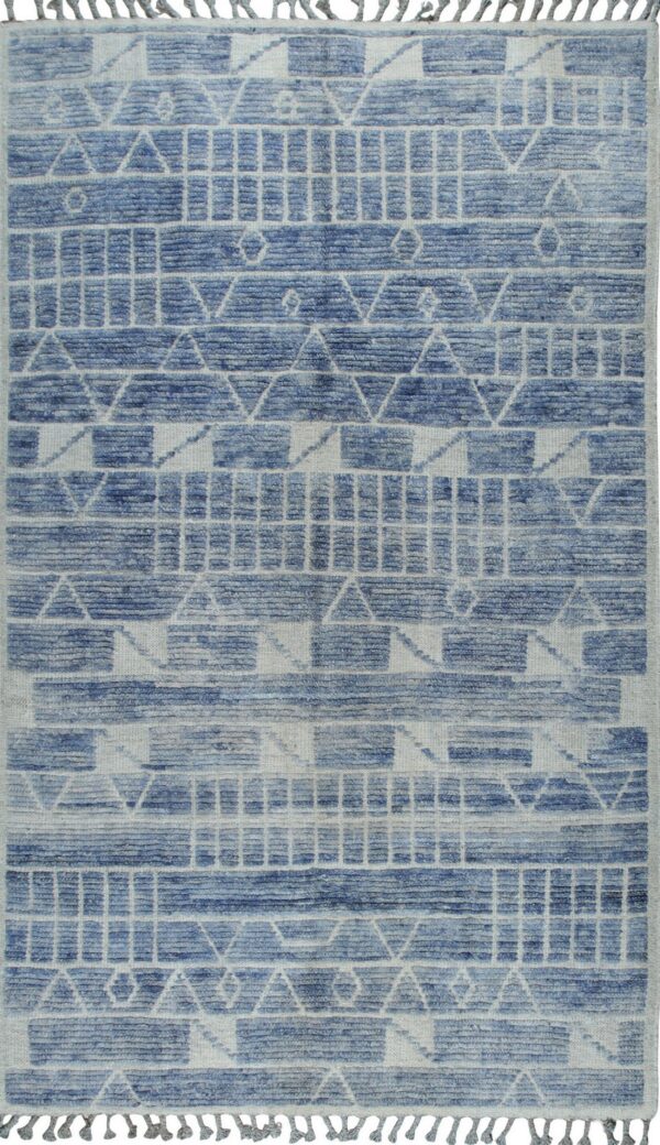 High-low pile rug in blue and white/gray with tribal geometric patterns and short fringed edges.