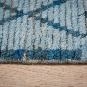 Textured high-pile rug in varying blues, displaying a geometric pattern on light wood flooring.