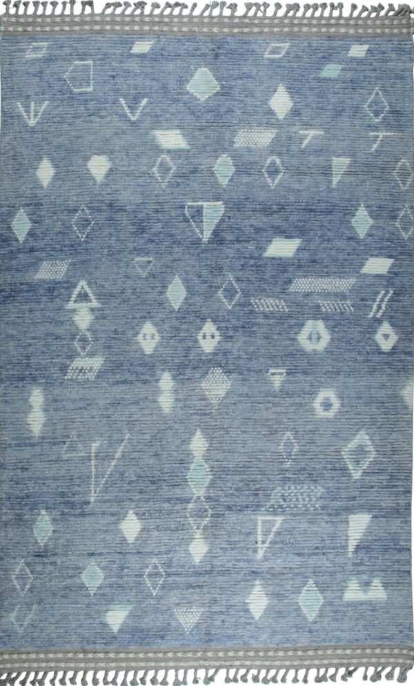 A blue rug featuring scattered white and teal geometric shapes, bordered by a gray band and tassels.