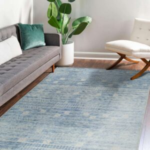 Variegated blue and beige patterned area rug grounds a living area with a gray couch and white accent chair.