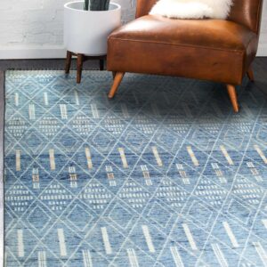 Blue textured rug with white and tan geometric patterns complements a distressed brown leather chair.