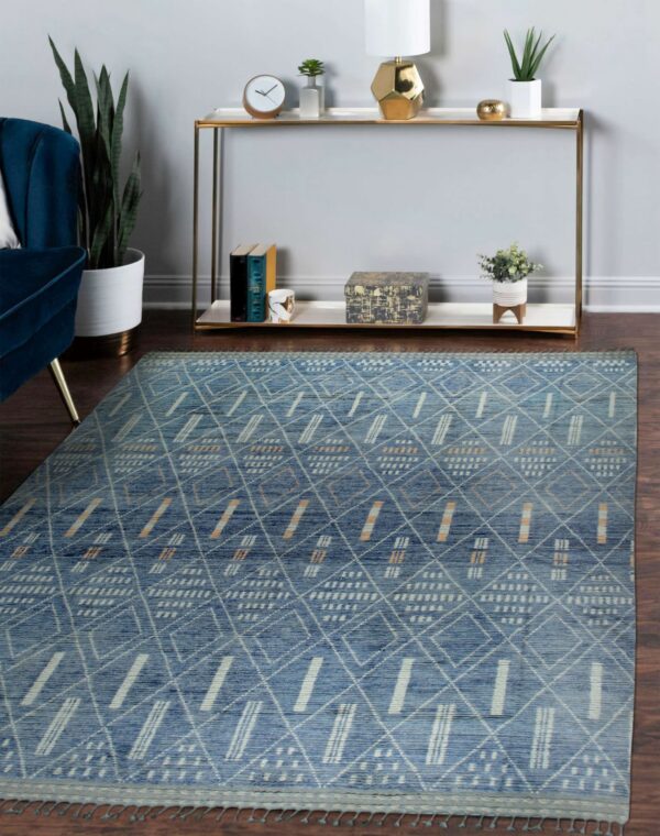 Blue geometric rug with white and tan patterns on dark wood floor near a gold console table.