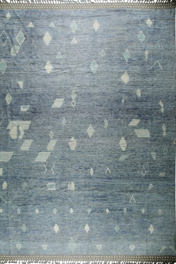 Textured blue rug featuring scattered pale cream and aqua geometric patterns with fringed gray borders.