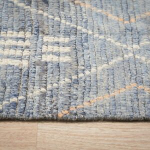 Chunky blue and cream high-pile rug with subtle peach diagonal accents rests on light wood flooring.