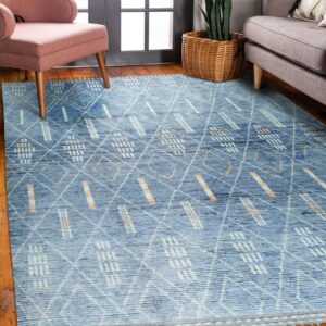 Blue textured rug featuring white and orange geometric diamonds, placed between pink and gray upholstered furniture.