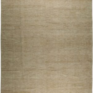 A rectangular solid beige area rug shows distinct horizontal texture and short white fringe edges.