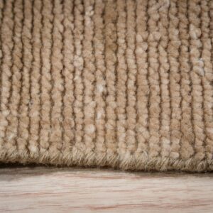 A close view shows a thick, beige, ribbed rug pile resting on light wood flooring.