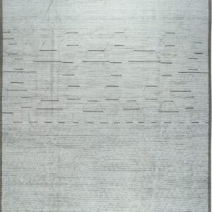 Light gray plush rug with textured horizontal rows, subtle geometric shapes, and gray tassels.