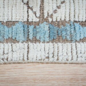 High-pile rug texture with abstract blue and cream bands resting on a light wooden surface.