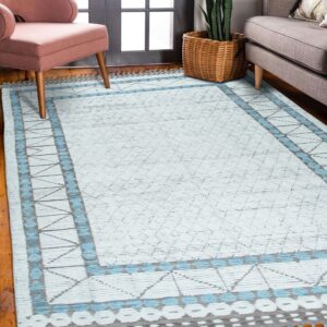 Light blue and gray geometric rug on wood floors between a pink armchair and a gray sofa.