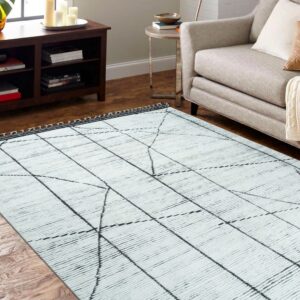 Textured white rug featuring a loose black grid design lies on wood flooring next to a gray sofa.