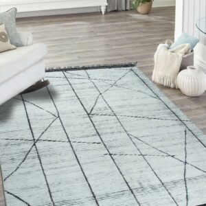 Ribbed white rug with black crisscrossing abstract lines lays on light grey wood flooring.