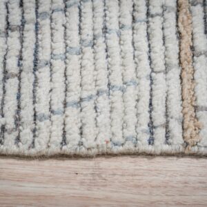 High-pile rug edge shows cream, blue, grey, and tan striped texture against light wooden flooring.