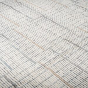 Cream high-pile rug texture with a geometric grid pattern in subtle gray, blue, and tan tones.