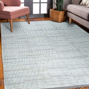White rug with fine gray linear patterns on wood floors, framed by a pink chair and gray couch.