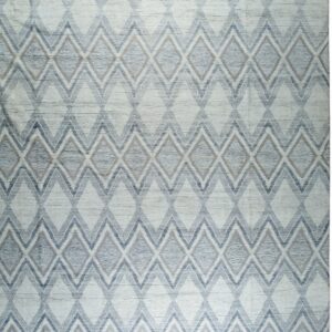 Light blue and white textured rug displaying a repeated geometric diamond and chevron pattern.