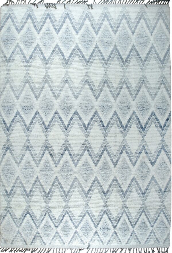 Textured white rug with blue and gray geometric zigzags and diamond patterns, detailed with fringe.