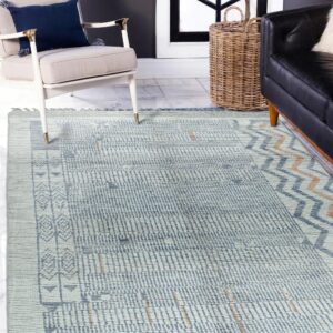 Light blue geometric rug on white tile flooring beside a cream chair and black sofa in a modern room.