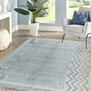 Light blue and cream low-pile rug with geometric and chevron patterns displayed on wood flooring.