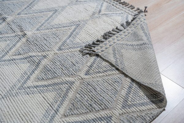 Textured cream and gray high-pile rug with geometric diamond pattern on light wood floors.