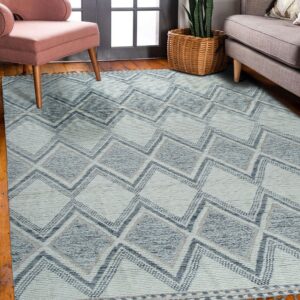 Blue and white geometric rug with visible texture variations sits on wood floor near pink and grey seating.