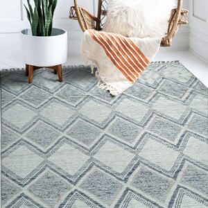Blue and cream geometric rug with textured diamond pattern, styled next to a wicker chair and potted plant.