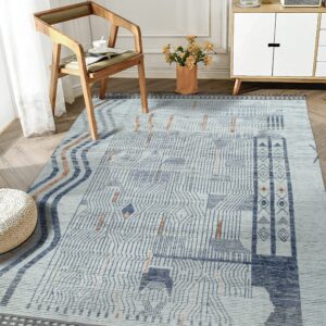 Geometric low-pile rug in light blue, indigo, and rust colors under a wooden armchair and white cabinet.