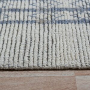 Close-up of a cream rug with vertical ribbed texture and light blue horizontal bands on light wood flooring.