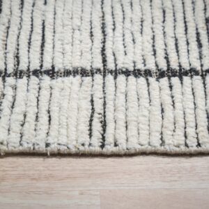 Chunky ivory high-pile rug with vertical black stripes detailed on light wood flooring.