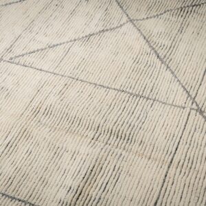 High-pile ivory rug featuring vertical textured rows and a sparse geometric pattern of thin gray lines.