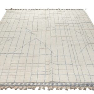 Textured cream rug with pale blue-gray geometric lines and gray decorative tassels at one end.