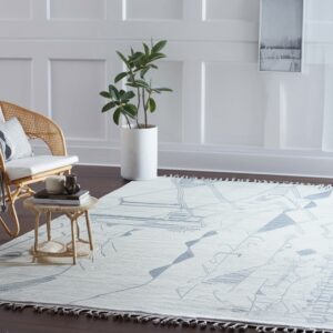 Light textured rug with a blue abstract geometric pattern on dark wood flooring in a paneled room.