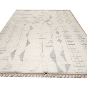 High-pile cream rug with gray abstract geometric symbols and fringes displayed on a light wood floor.