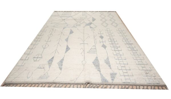 High-pile cream rug with gray abstract geometric symbols and fringes displayed on a light wood floor.