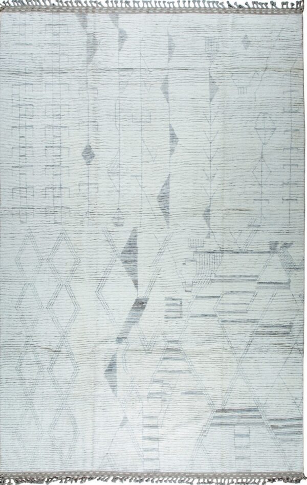 White textured rug displaying an abstract geometric pattern in faded shades of gray, with short tassels.