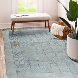 Light blue geometric rug with tan accents rests on wood flooring near a bench and window.