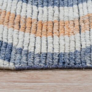 High pile rug detail showing textured rows of blue, cream, and orange on light wood flooring.