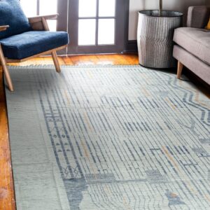 White and blue abstract rug with orange lines rests on hardwood floors near a blue chair.