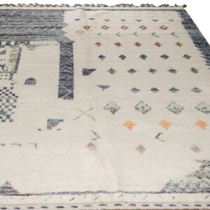 Off-white rug with dense blue geometric patterns along the edges and scattered blue and peach motifs.