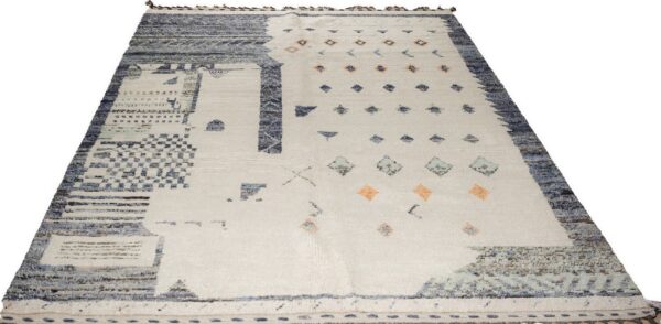 Off-white rug with dense blue geometric patterns along the edges and scattered blue and peach motifs.