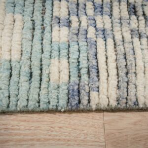Thick pile rug with vertical blocks of cream, light blue, and dusty blue, displayed on light wood floor.