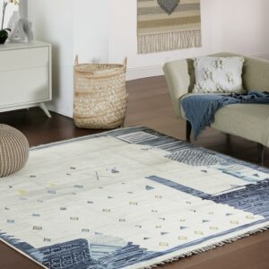Abstract cream and indigo rug with scattered yellow geometric shapes anchors a room with wood floors and a chair.