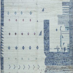 High-pile off-white rug featuring abstract blocks of blue and scattered small geometric motifs in magenta and teal.