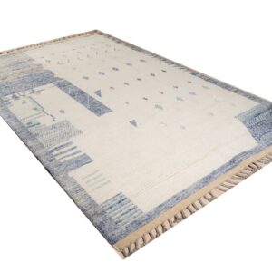 High-pile cream rug with abstract borders and geometric shapes in blue, light blue, and pink.