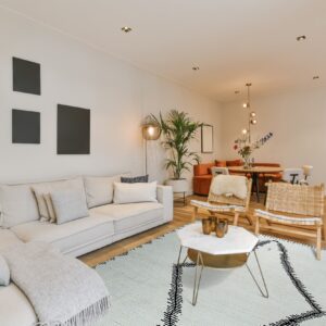 A light green low-pile rug with bold black zigzag lines anchors a neutral living room with white seating.