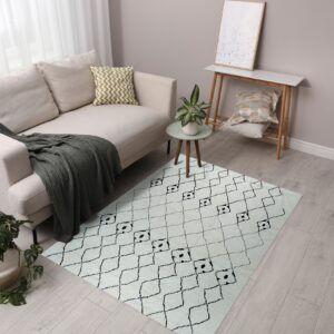 A cream rug with a black geometric diamond pattern sits on light wood flooring next to a beige sofa.