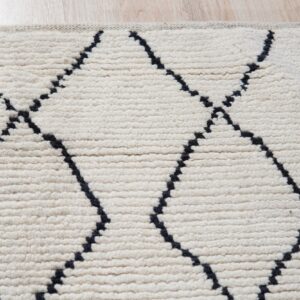 High-pile cream rug with dark dotted geometric trellis lines rests on light wood floor.